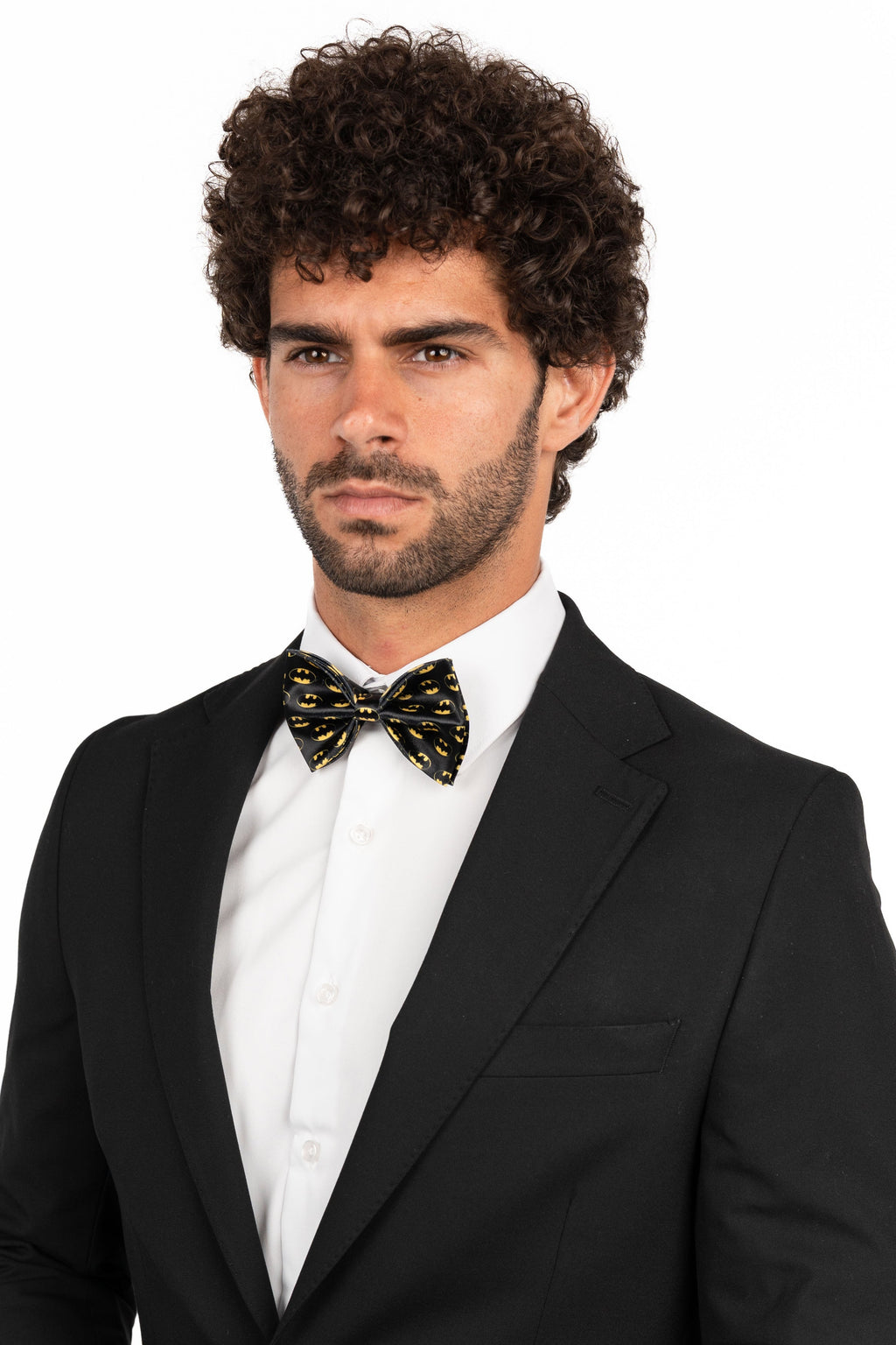 Man wearing a black tuxedo with a white shirt and bow tie on a white background