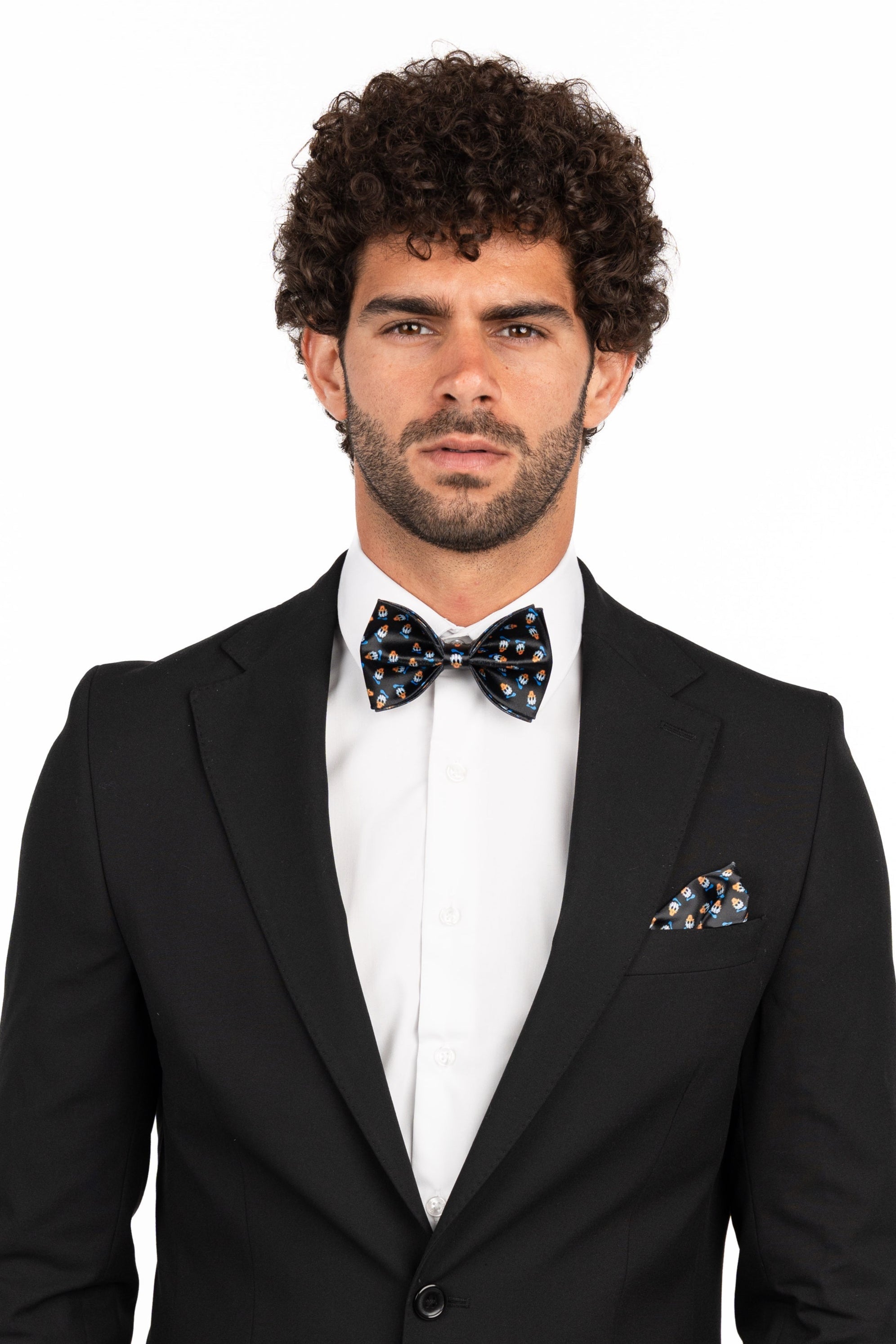 Man wearing a black suit with a bow tie on a white background