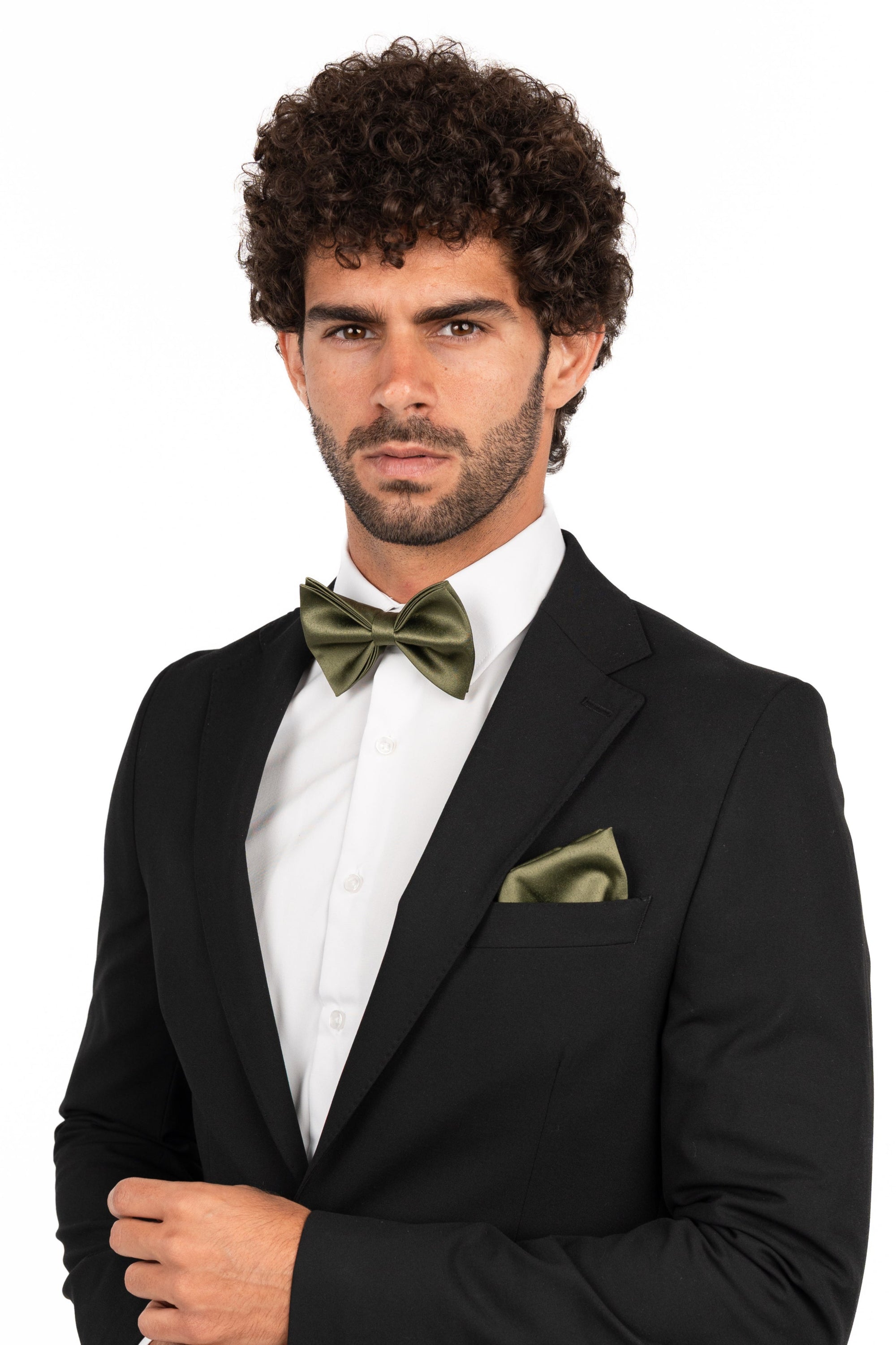 Man wearing a black suit with a white shirt and green bow tie and pocket square on a white background