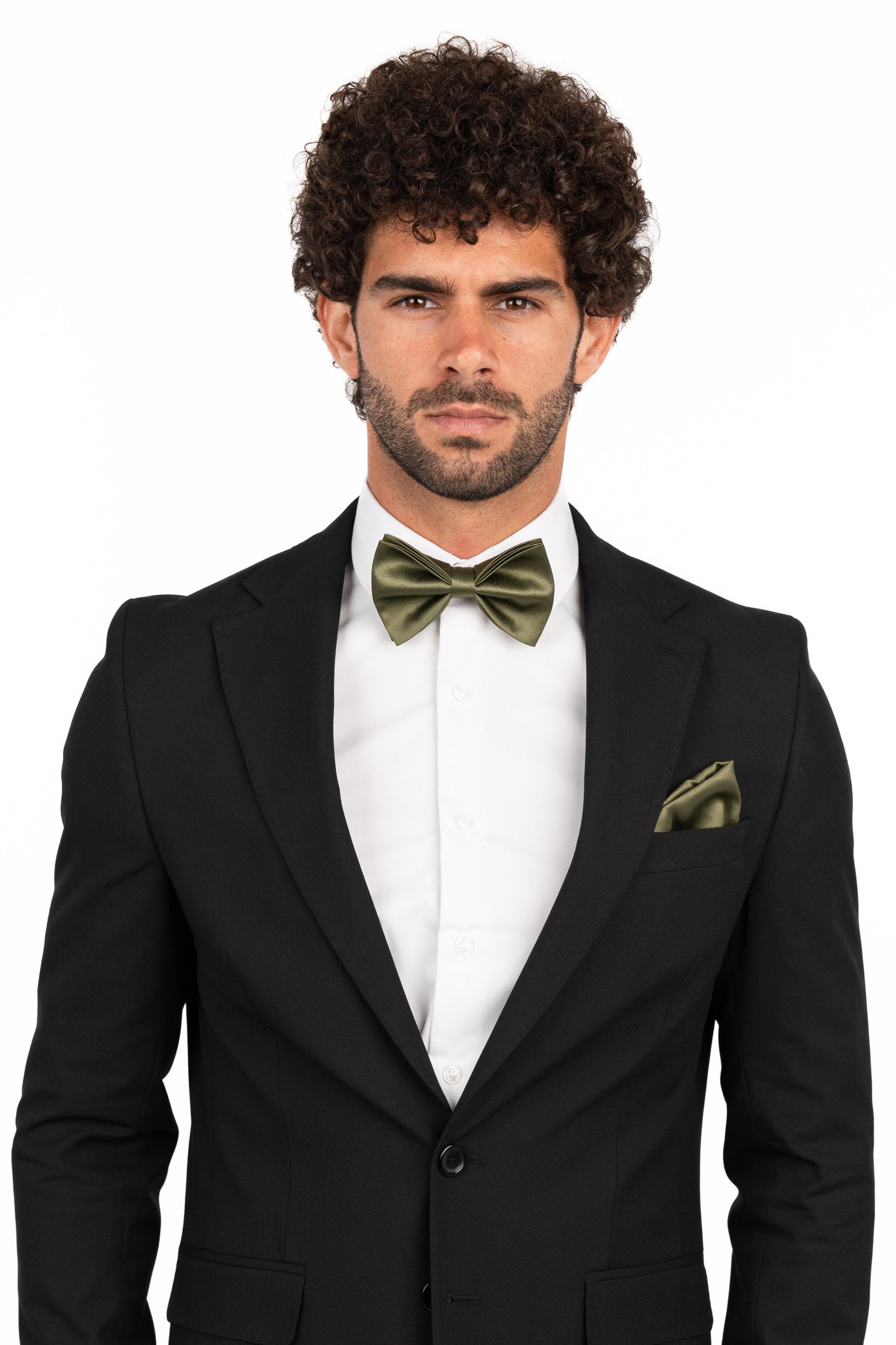 Man wearing a black suit with a white shirt and green bow tie and pocket square on a white background