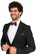 Man wearing a black tuxedo with a bow tie and pocket square on a white background