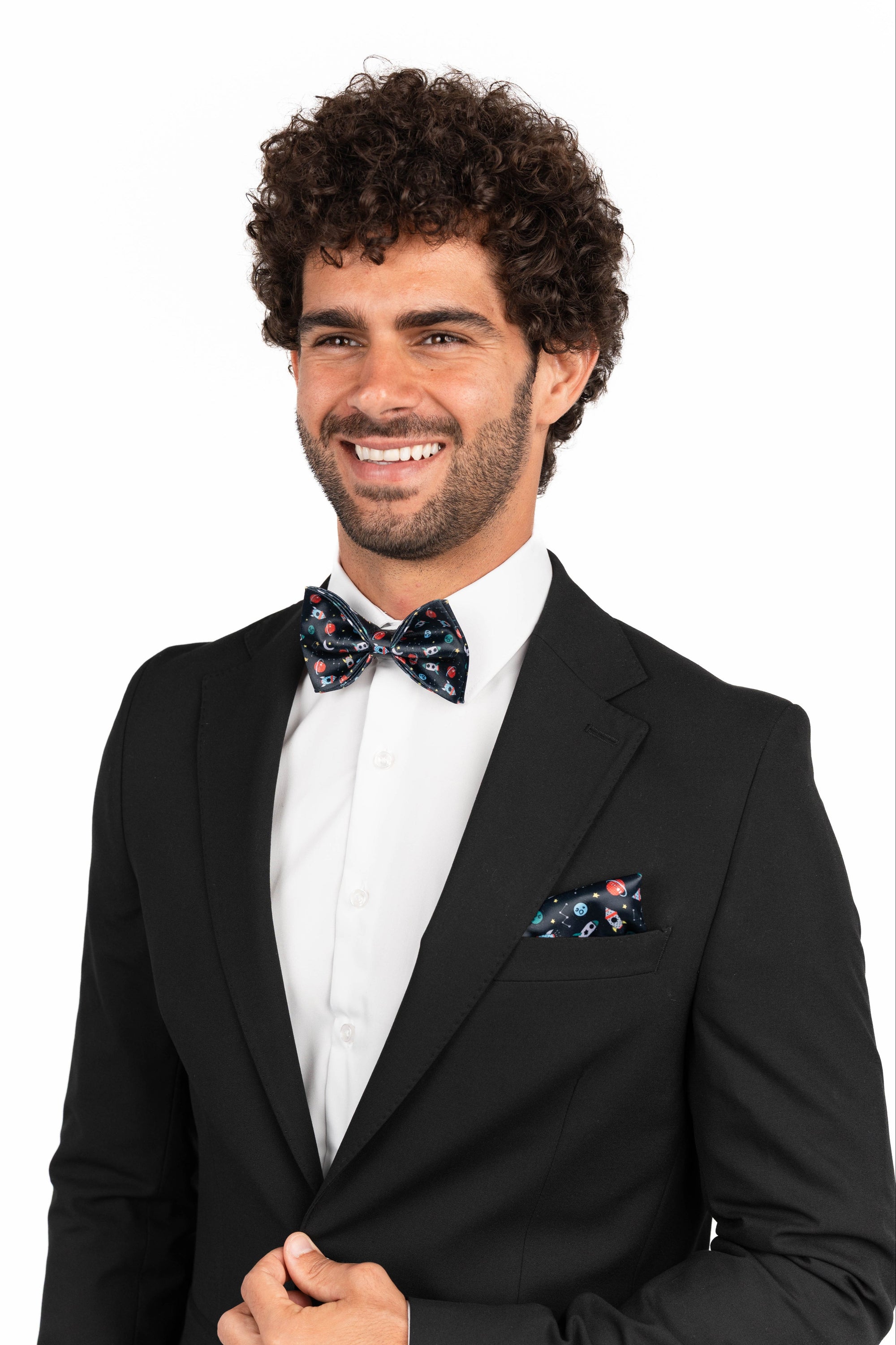Man wearing a black suit with a floral bow tie and pocket square on a white background